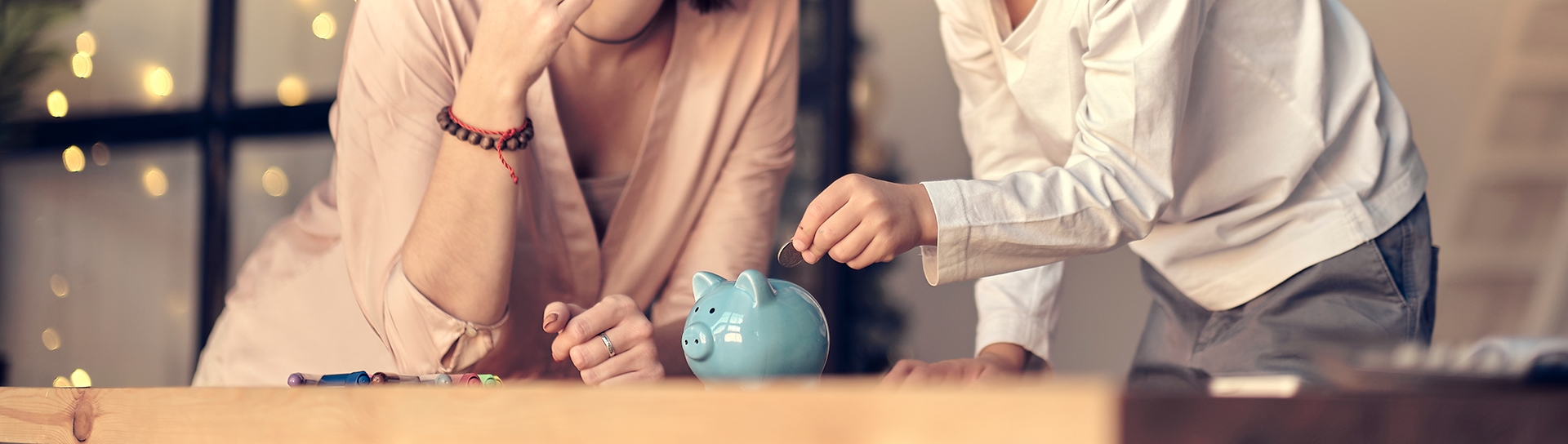 child putting money in piggy bank